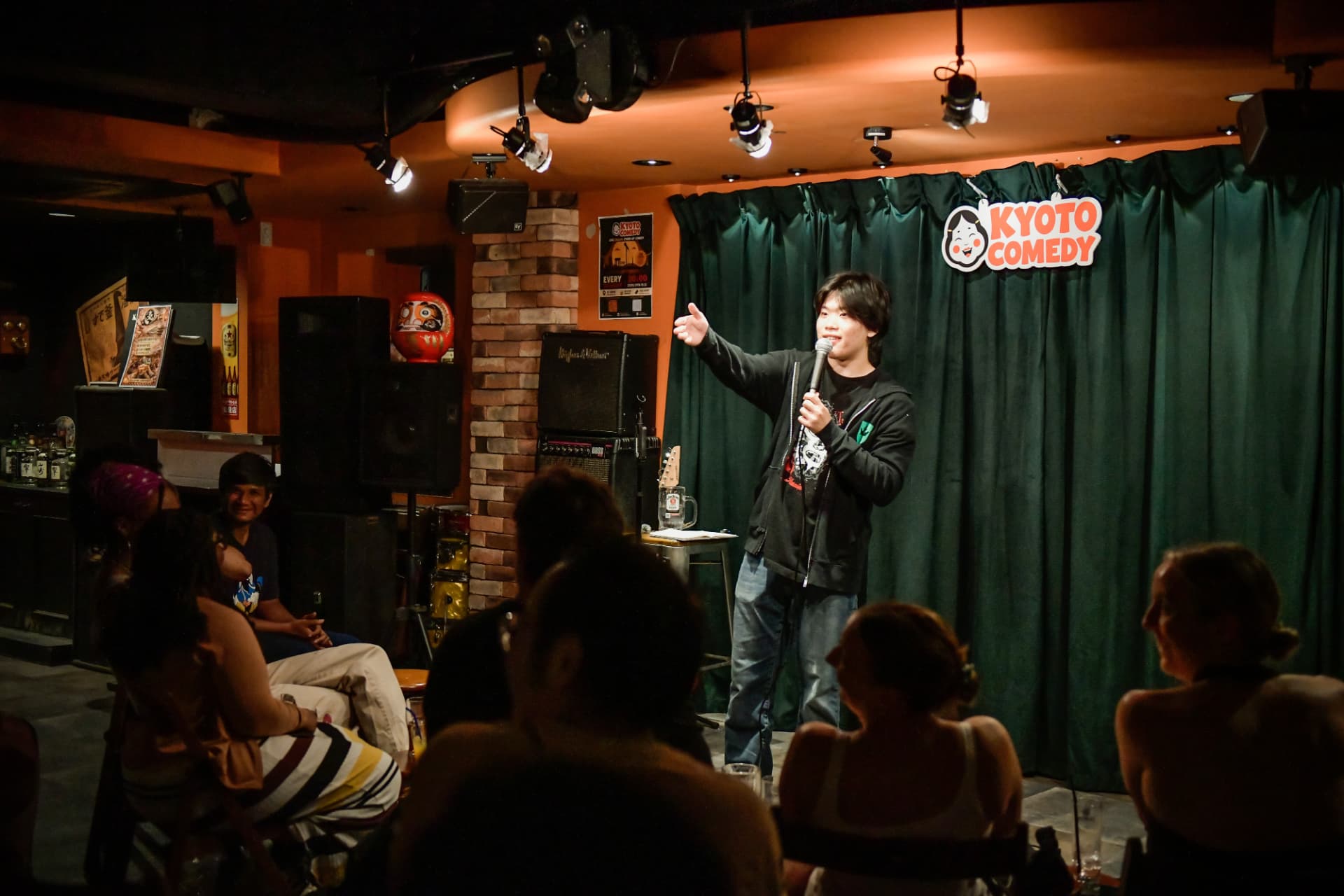 Young Japanese comedian performing English stand up comedy for the crowd at Kyoto Comedy