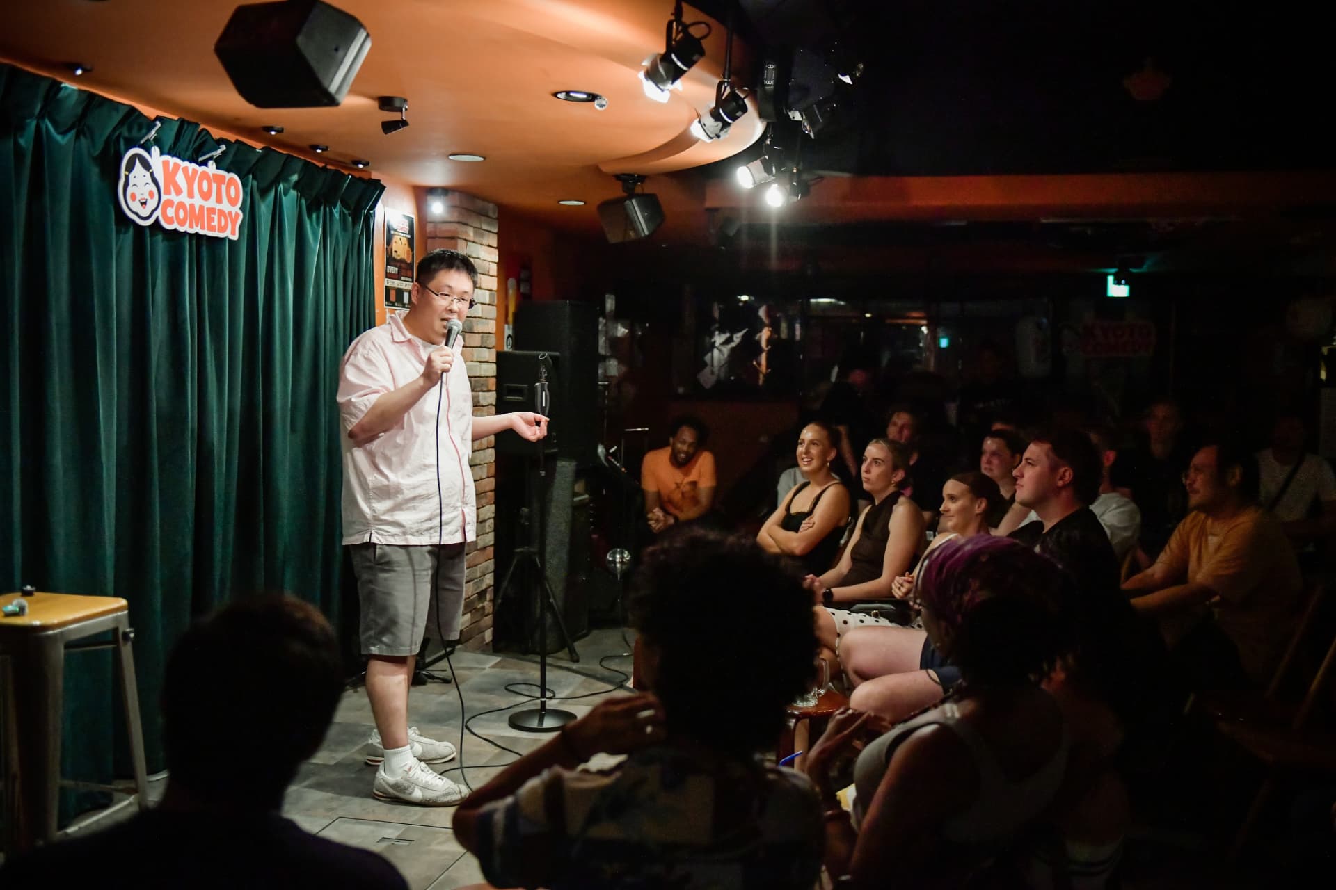 Comedian performing live on stage at a Kyoto Comedy show